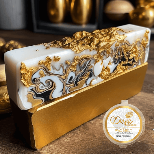 A luxurious, gold-flecked white bar labeled "Nag Champa" by Daya's Essence rests on a gold stand, promising a richly scented and mystical fragrance experience.